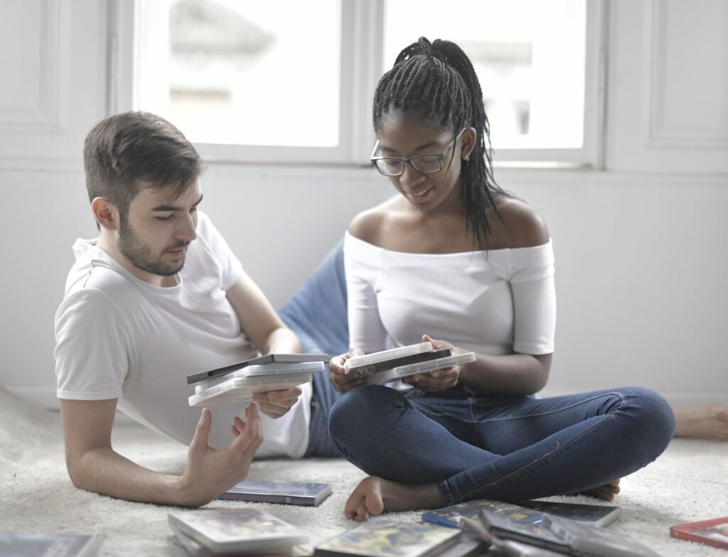 couple sitting on the floor choosing what movie to watch