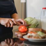 woman cooking cutting vegetables for sandwiches