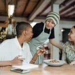 cheerful colleagues tasting food in cafeteria