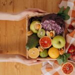 person holding a basket of fruits