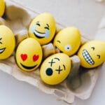 yellow painted eggs with various facial expressions
