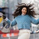 happy woman jumping with shopping bags