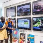 photo of a salesman selling a television to a customer