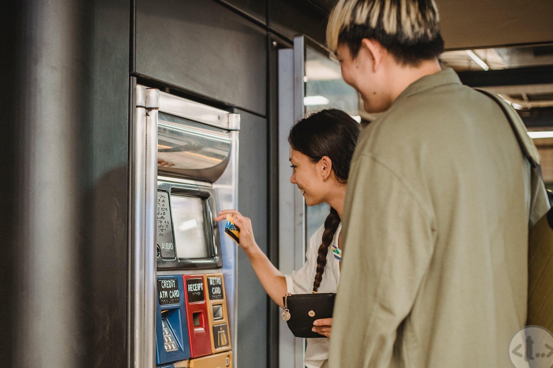content couple using ticket machine in underground