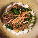 close up photo of scrumptious meat dish topped on rice