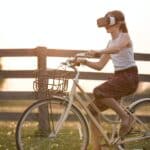 girl wearing vr box driving bicycle during golden hour
